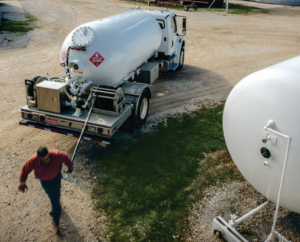 Truck filling propane tank in rural area.
