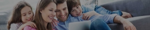 A man and boy laying on the ground looking at a laptop.