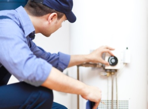 Technician adjusting a water heater dial.