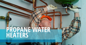 A man in an orange hat and gloves working on pipes.