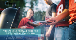 A group of people standing around a grill.