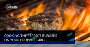 A burger is cooking on the grill with flames.