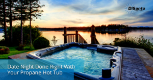 A hot tub with the sun setting over a lake.