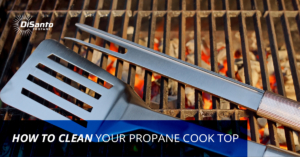 A grill with an open lid and two forks.