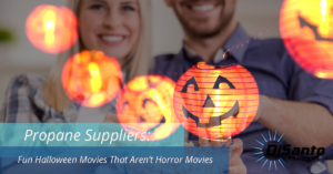 Two people holding a glowing jack o lantern.
