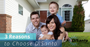 A family posing for the camera in front of their home.