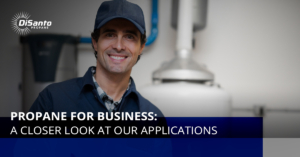 A man in blue shirt and hat next to water heater.